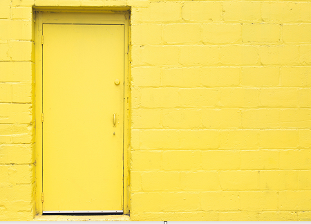 Yellow door in yellow brick wall
